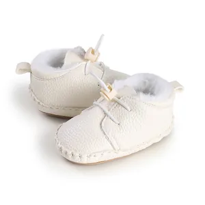 Nahaufnahme von warmen, plüschgefütterten Babyschuhen mit genarbter Lederstruktur