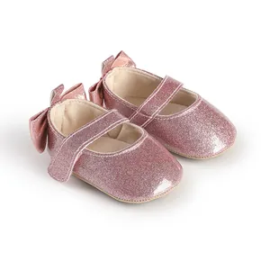 Close-up of pink glitter baby girl walking shoes with a bow detail on the back