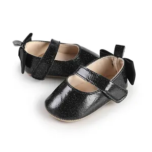Macro detail of sparkly black baby girl Mary Janes featuring elegant back bow accents