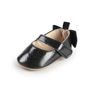 Close-up of black glitter baby Mary Jane shoes with velcro strap and heel bow