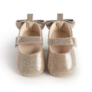 Detailed view of sparkling gold baby girls' walking shoes with cute bow design.