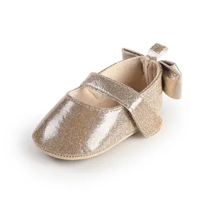 Macro detail of sparkly gold baby girl pre-walker shoe with an elegant heel bow