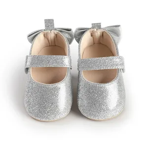 Detailed view of shiny silver glitter baby girl walker shoes featuring back bow