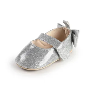 Detailed view of silver glitter baby Mary Jane shoes featuring a stylish bow decoration