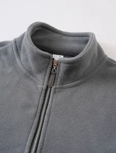 Detail shot of men's grey fleece jacket featuring a half-zip and stand collar design.