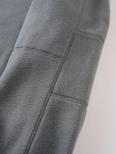 Macro detail of high-quality grey polar fleece fabric with durable double-needle stitching.