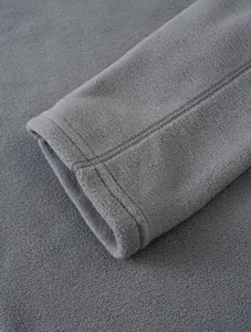 Close-up detail of gray polar fleece jacket cuff showing premium stitching and texture.