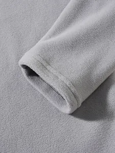 Macro detail of a soft grey polar fleece sweatshirt sleeve cuff showing fabric texture