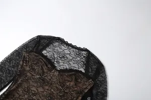 Close-up detail of the intricate black floral lace pattern on long-sleeved evening dress