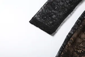 Close-up detail of black lace sleeve showing intricate floral pattern and fine mesh texture.
