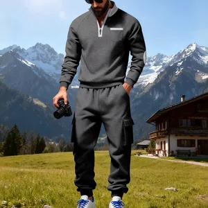 Chándal de forro polar gris pesado para hombre con pantalones cargo en entorno de montaña.