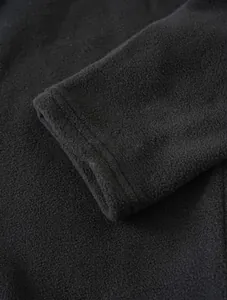 Macro detail shot showing the soft texture of black polar fleece sweatshirt sleeve cuff