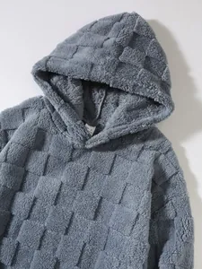 Detailaufnahme eines grauen Plüsch-Hoodies mit einzigartigem quadratischem Gittermuster