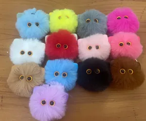 A detailed collection view of colorful plush cat head keychains on wooden surface