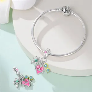 Detail showing travel theme silver-plated charms with bikini and palm tree designs