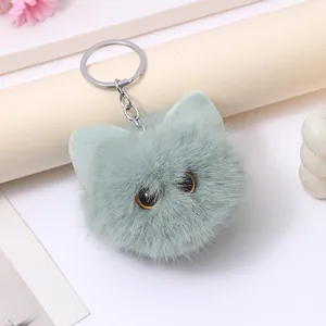 Close-up of cute mint green plush cat head keychain with realistic big eyes