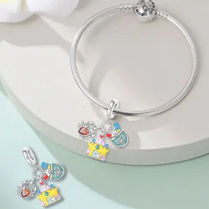 Detailed view of silver-plated beach charms featuring crab, castle and bucket design