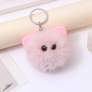 Detailed view of a cute pink plush cat head keychain with soft fur and large black eyes