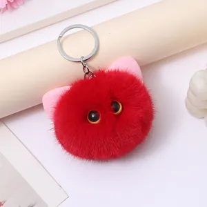 Detailed close-up view of a cute red plush cat head keychain with soft pink ears