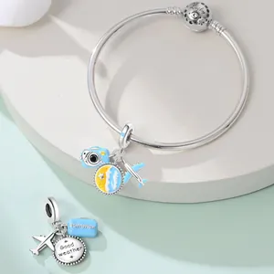 Detail view of silver travel charms including airplane, camera and beach theme