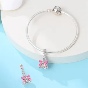 Close-up detail view of silver-plated Eiffel Tower charm with pink bow and zircon accents