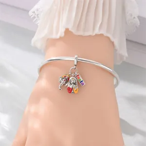 Detail shot of silver-plated charm bracelet with colorful India theme icons on wrist
