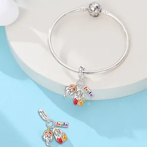 Detailed view of India-themed charms with Ganesha and sari figure on a silver bracelet