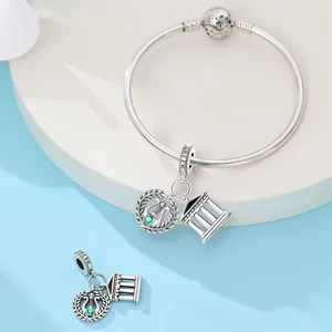 Detailed view of silver-plated Greek temple and harp charms on a stylish travel bracelet.