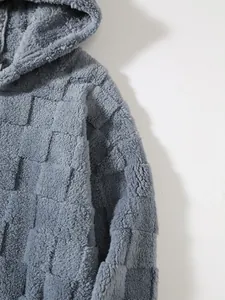 Makro-Detailansicht des grauen Plüsch-Hoodies mit weicher Karo-Stoffstruktur.