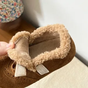 Close-up of soft beige plush lining inside brown suede winter shoes for toddler girls