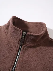 Detail view of the standing collar and zipper on this brown fleece pullover jacket