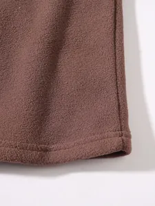 Close-up of soft brown fleece fabric showing fine stitching on a men's sweatshirt.
