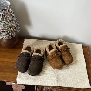 Close-up of toddler girls warm winter shoes with fur lining and bow details