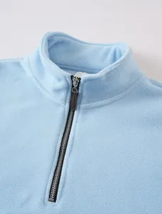 Close-up of the zipper and soft fleece texture of this light blue men's sweatshirt.