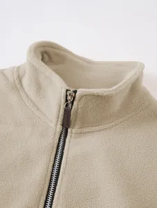 Close-up detail of a beige men's fleece sweatshirt with a stand collar and half-zipper.