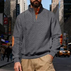 Detailansicht grauer Jacquard-Struktur mit leuchtend orangen Ellbogenschonern und Kragen