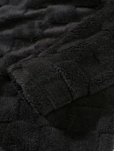 Makroansicht von schwarzem Fleece-Stoff mit einem strukturierten Karomuster-Design.
