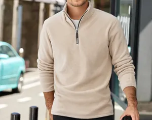 Macro view of men's thick beige fleece sweatshirt with half-zip stand collar