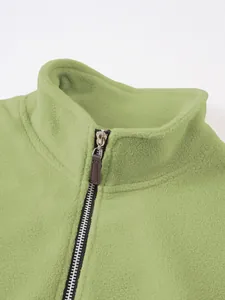 Close-up of light green men's fleece jacket with stand collar and zipper detail.
