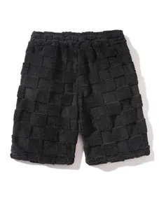 Detailansicht einer schwarzen, flauschigen Herren-Shorts mit geprägtem, stilvollem Schachbrettmuster