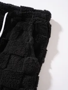 Detailansicht der schwarzen Herren-Sherpa-Fleecehose mit Karomuster und Kordelzug.