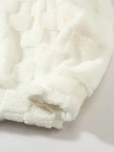 Detailansicht von weißem Flauschstoff mit einem geprägten quadratischen Karomuster
