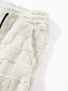 Detailansicht der weichen cremefarbenen Plüsch-Karo-Struktur mit Bund- und Taschendetails