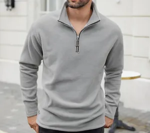 Close-up of a men's light grey fleece sweatshirt with a half-zip stand collar design.