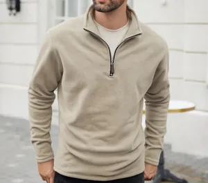 Detailed view of a men's solid beige polar fleece sweatshirt with quarter-zip stand collar.