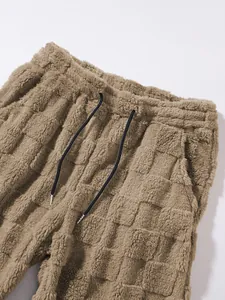 Detaillierte Ansicht der flauschigen Karo-Textur und des Bundes der warmen Herrenhose.