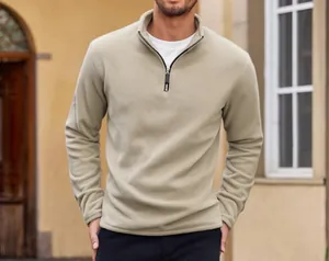 Detail of a khaki men's fleece sweatshirt with half-zip stand collar outdoors.