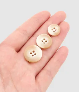 Close-up of premium resin buttons in varying sizes held by hand