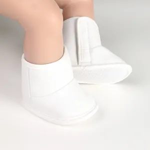 Close-up of white baby boots with soft anti-slip soles and hook-and-loop straps
