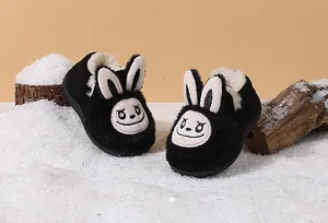 Close-up of black fuzzy toddler snow boots with cute cartoon rabbit ears and face design